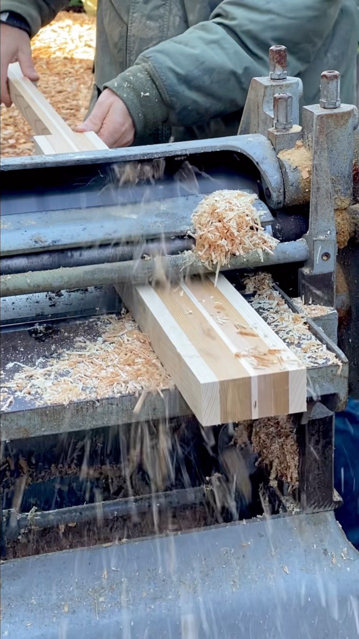 a striped laminated greenland paddle blank being run through a thickness planer