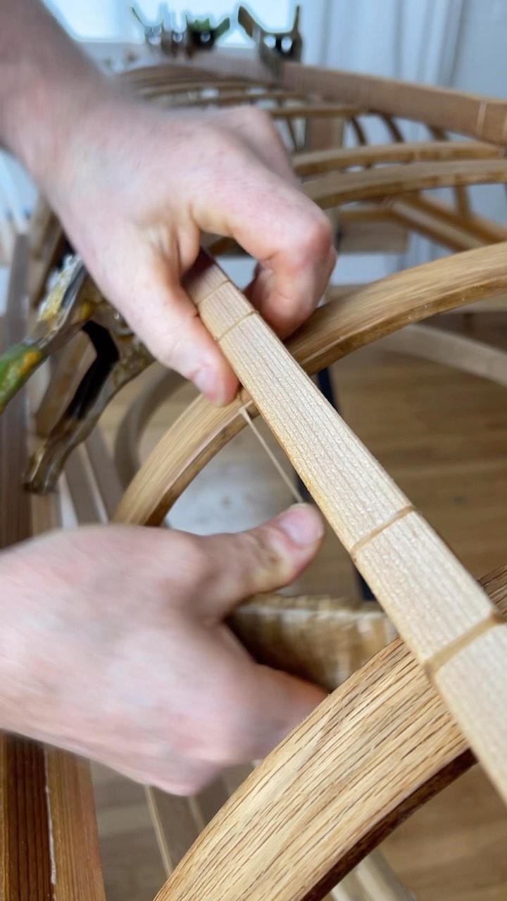 hands tying kayak stringers to frame with artificial sinew
