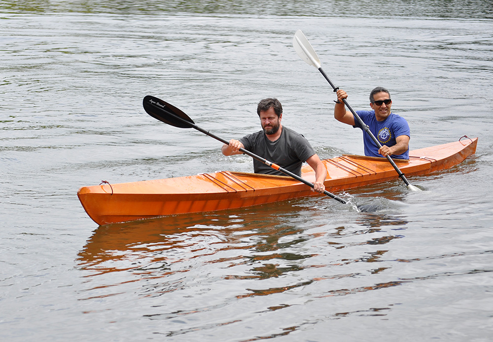 two men paddling a skin on frame tandem kayak