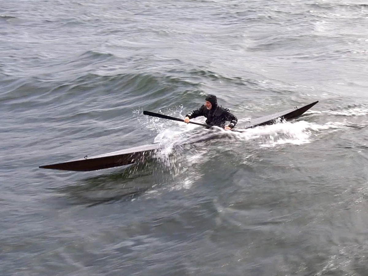 kayaker surfing a west greenland skin on frame kayak