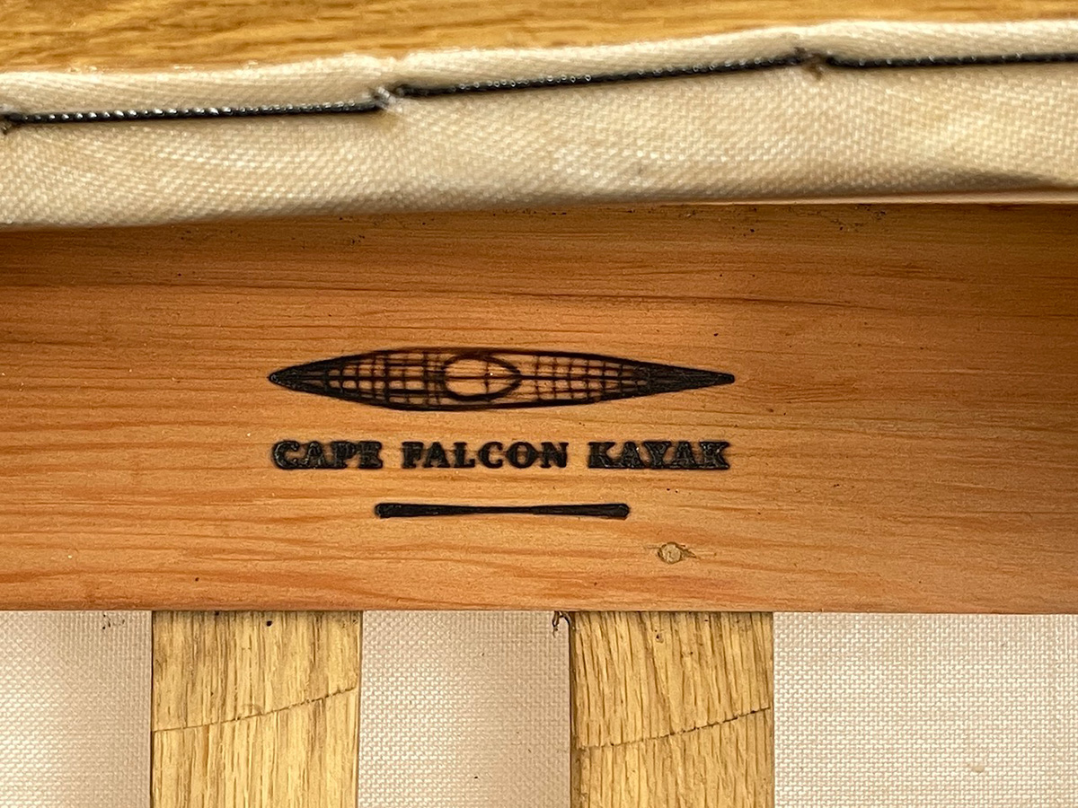 inside of a wooden kayak gunwale burnt with the Cape Falcon Kayak brand
